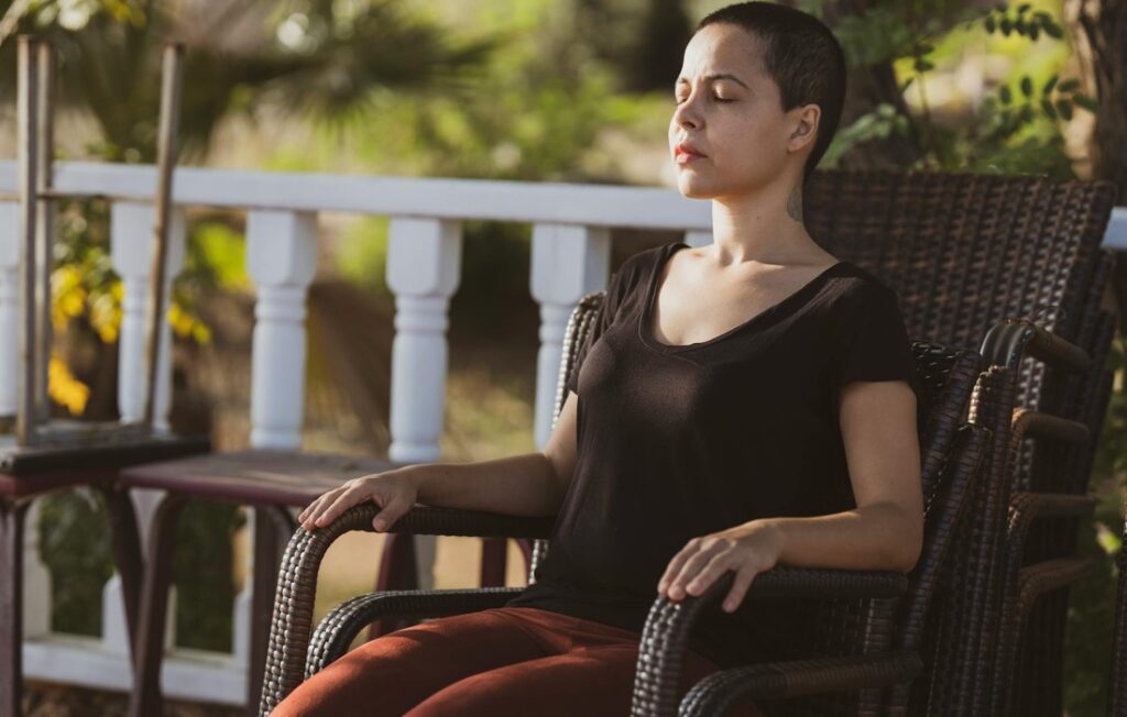 Sitting in a chair meditating.